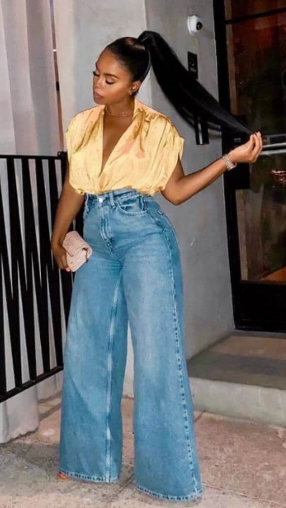 Mulher usando look com calça pantalona jeans e camisa de seda 